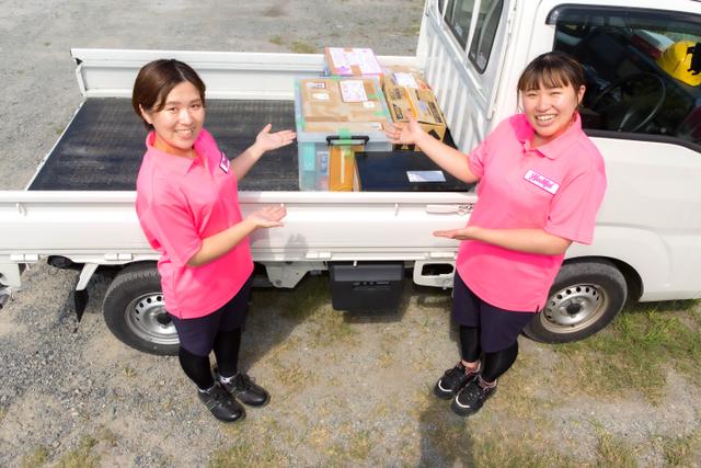 トラックに積んだ不用品とハートフル広島のスタッフ写真